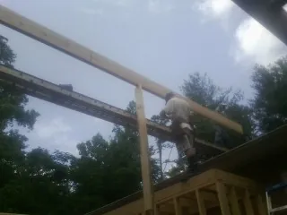 Carpenter setting a ridge beam over a new addition frame — Ice Dam Removal by Roofing Brothers in Rolla