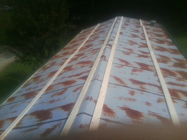 Rusted metal roof panels with new wood purlins before replacement — Storm Damage Roof Repair in Rolla by Roofing Brothers