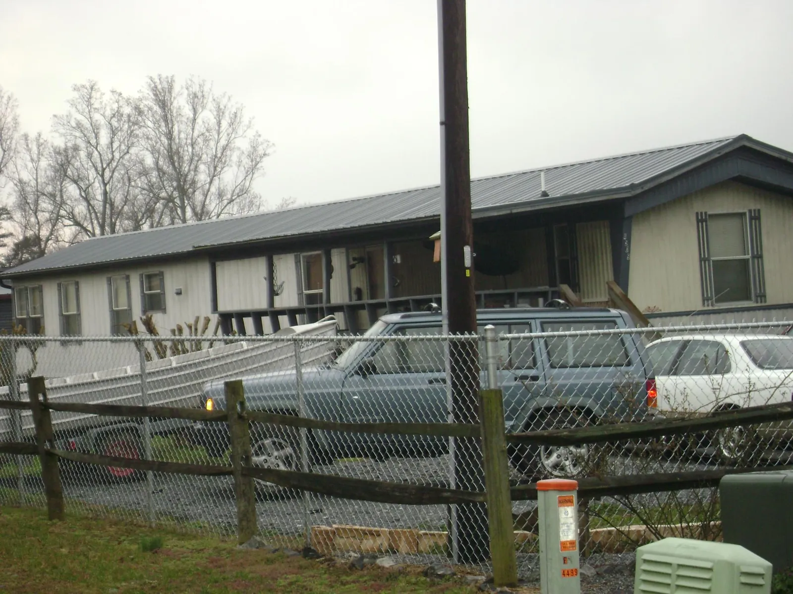 Dark metal roof on a long single story building behind a chain link fence in Rolla