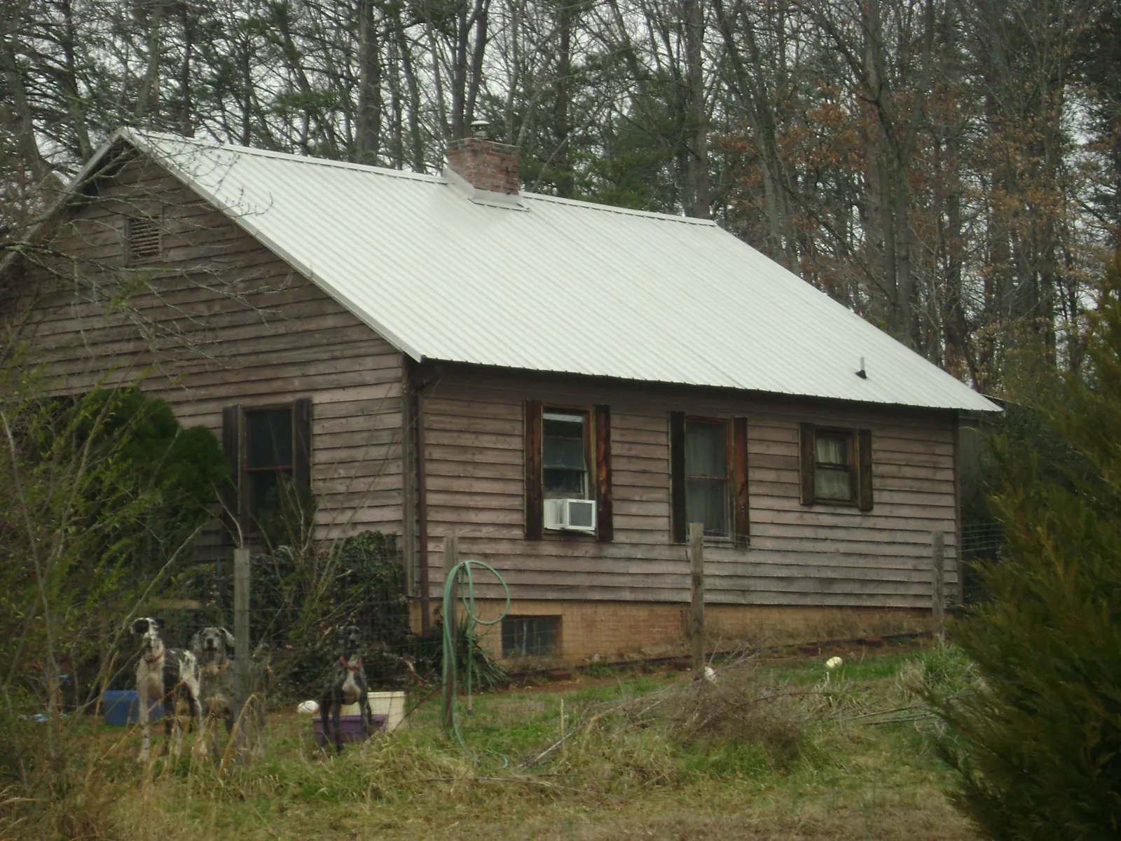 White metal roof on an old wood sided farmhouse, from a Metal Roof Installation job in Rolla